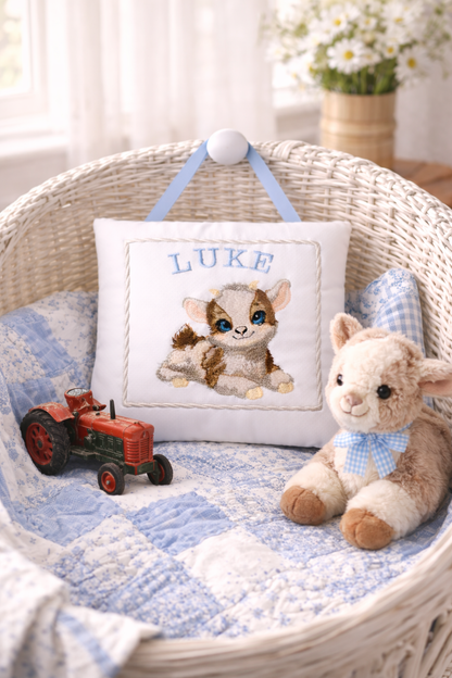 Baby basket with personalized  music box pillow, stuffed animal, and toy tractor.