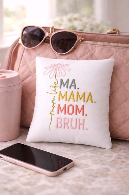 Music box pillow with text on a surface with sunglasses, phone, and cup.