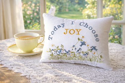 Decorative music box pillow with 'Today I Choose Joy' text on a table with a cup and saucer.