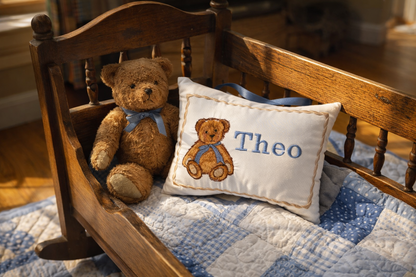 Teddy bear with a music box pillow named 'Theo' on a wooden bed with blue and white checkered bedding.