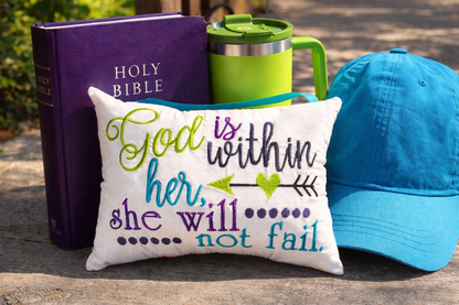 Music box pillow with motivational quote, Bible, mug, and cap on a wooden surface