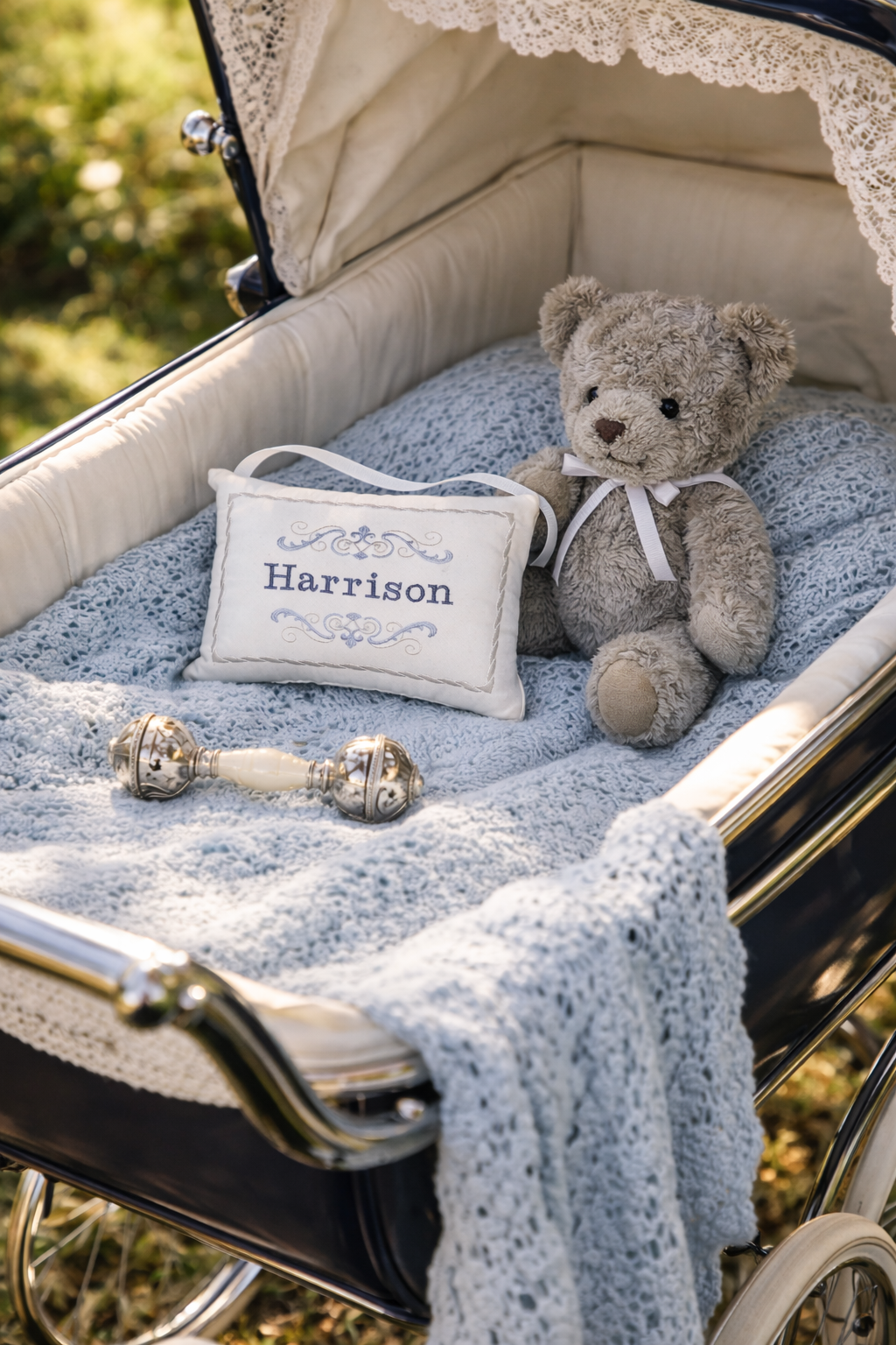 Baby carriage with teddy bear, music box pillow, and rattle on a blurred natural background