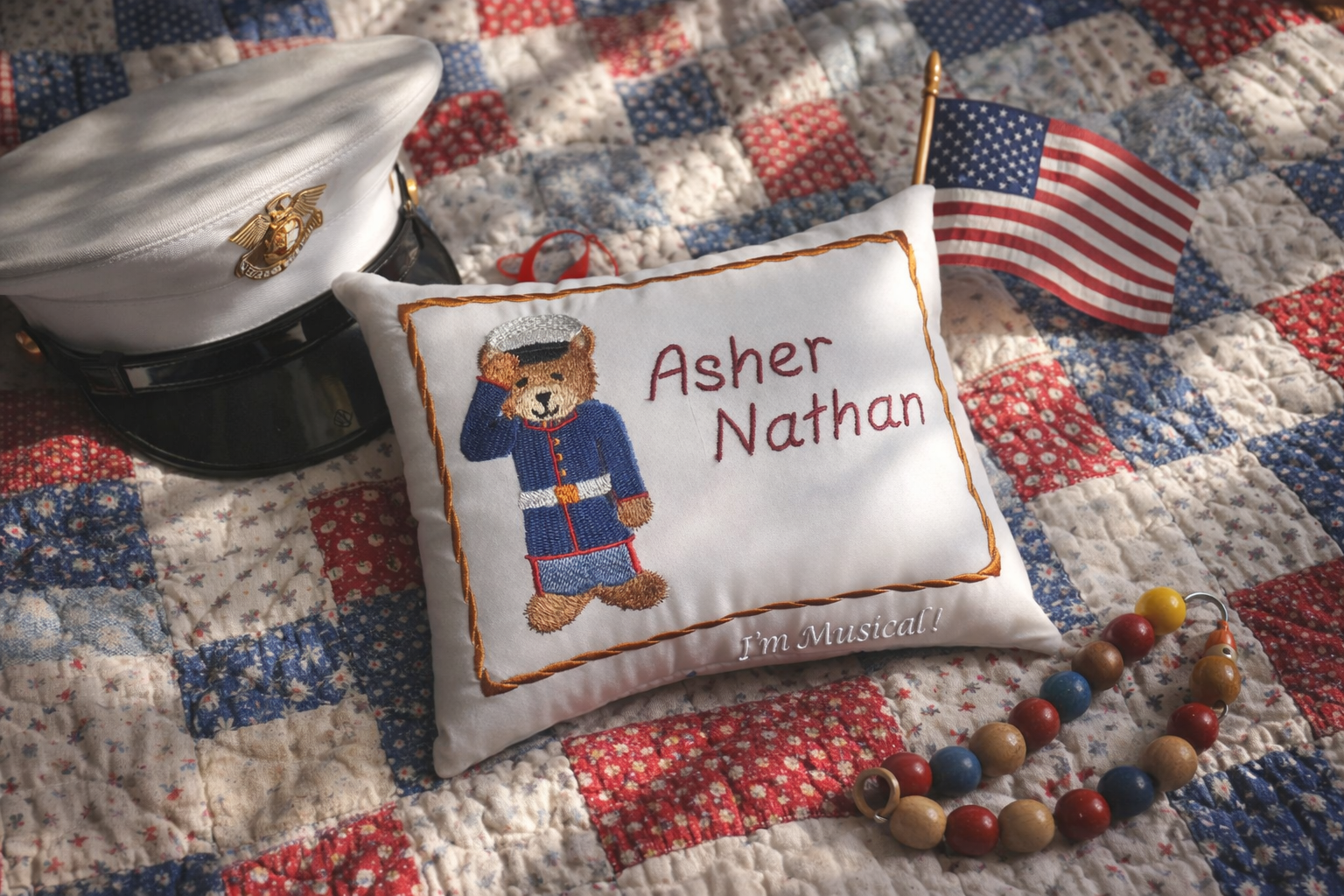 Decorative music box pillow with teddy bear design and text on a quilted surface with a hat and beads.