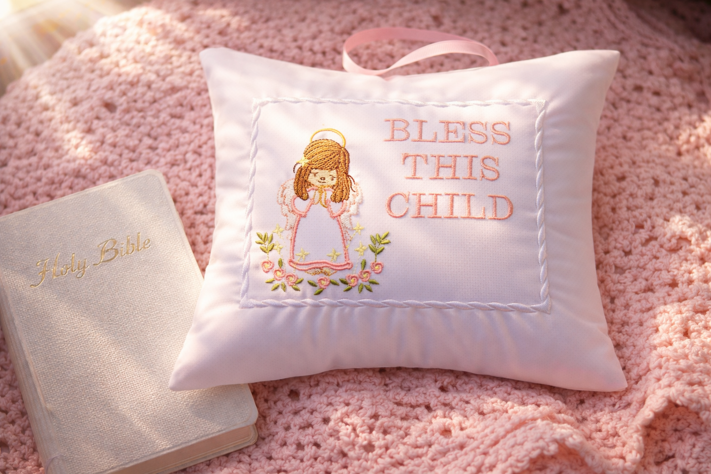 Decorative music box pillow with embroidered text and angel design on a pink textured surface