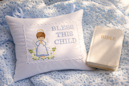 Decorative music box pillow with 'Bless This Child' text and a Bible on a textured surface