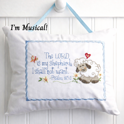 Decorative music box pillow with embroidered sheep and text on a white background