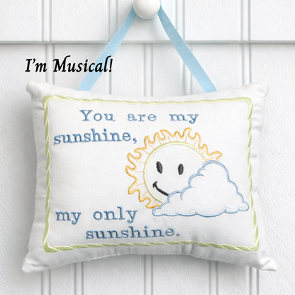 Music box pillow with sun and cloud design and text 'You are my sunshine, my only sunshine.'