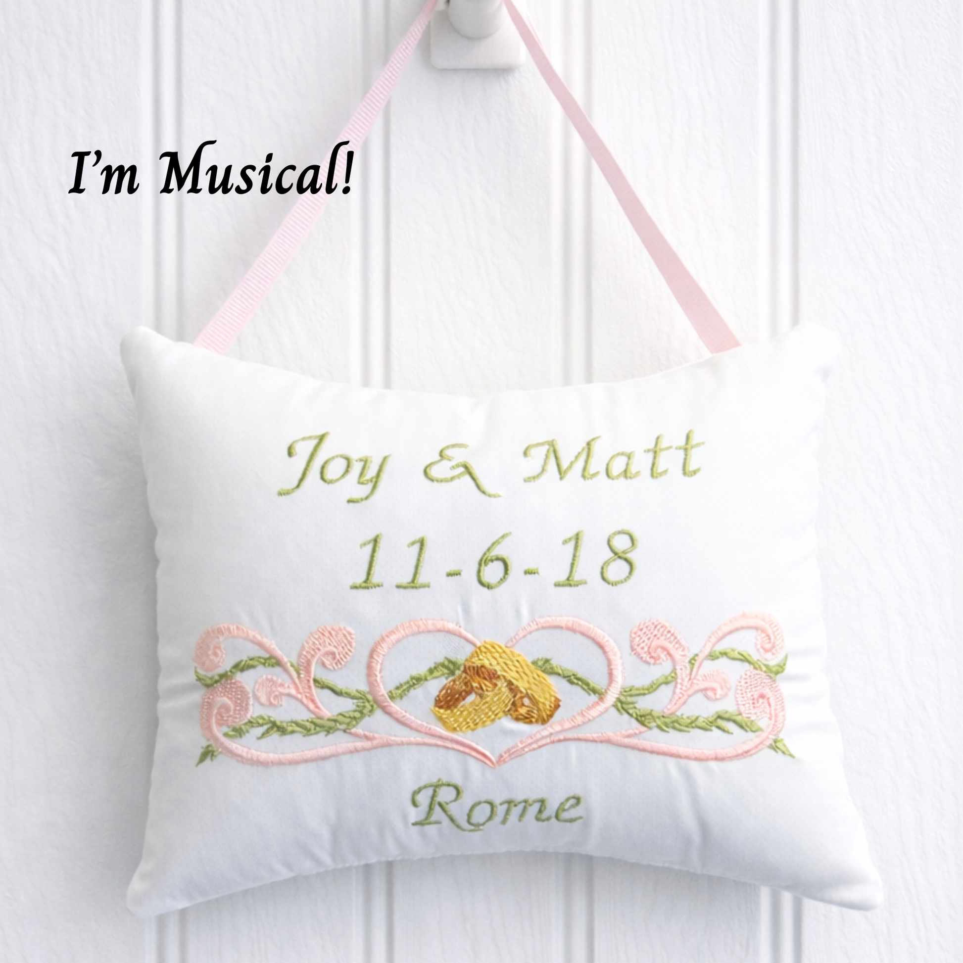 Decorative music box pillow with embroidered text and design on a white background