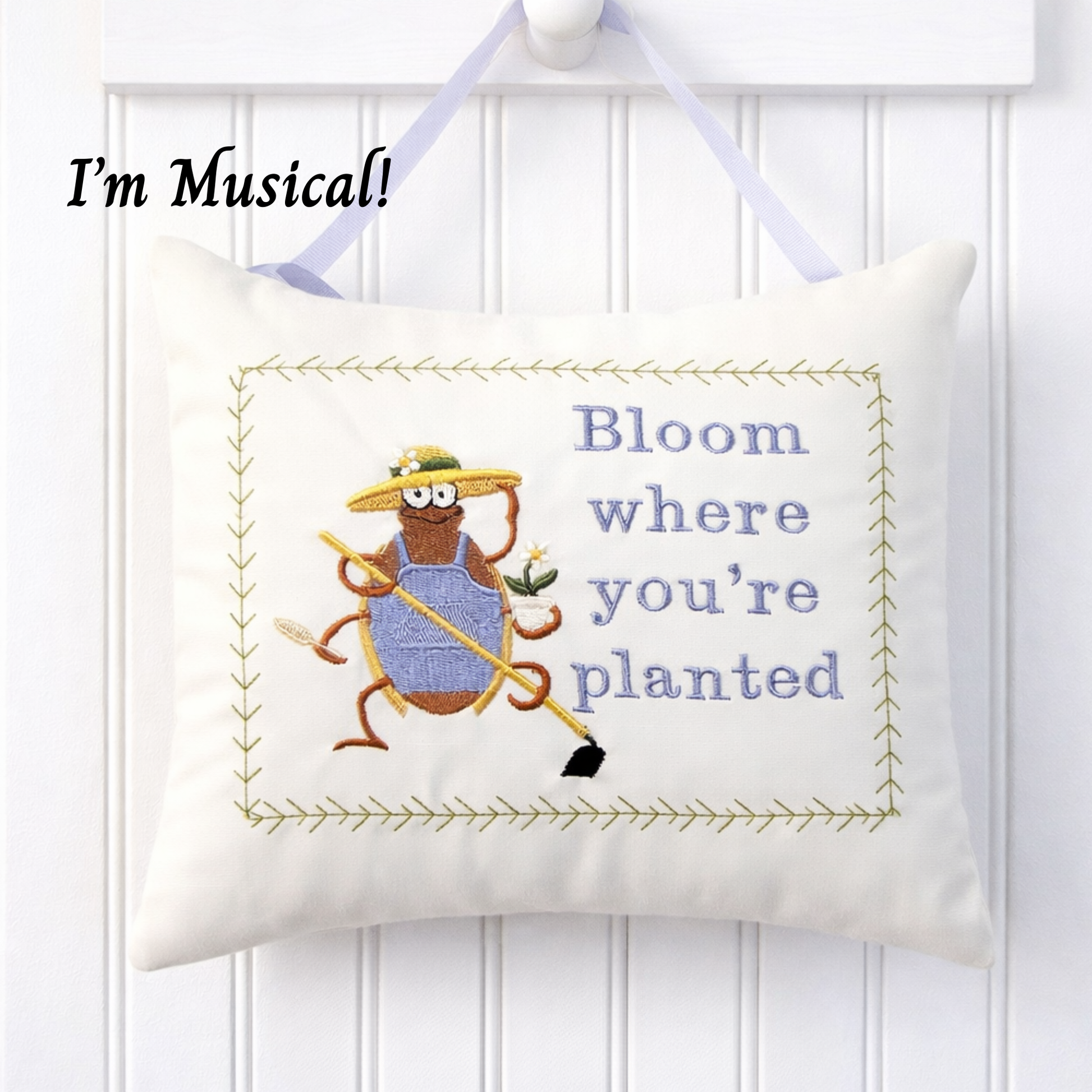 Decorative music box pillow with gardening bug and text on a white background