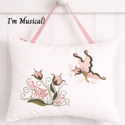 Decorative music box pillow with floral designs and text on a white background