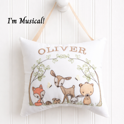 Decorative music box pillow with animals and 'OLIVER' text on a white background
