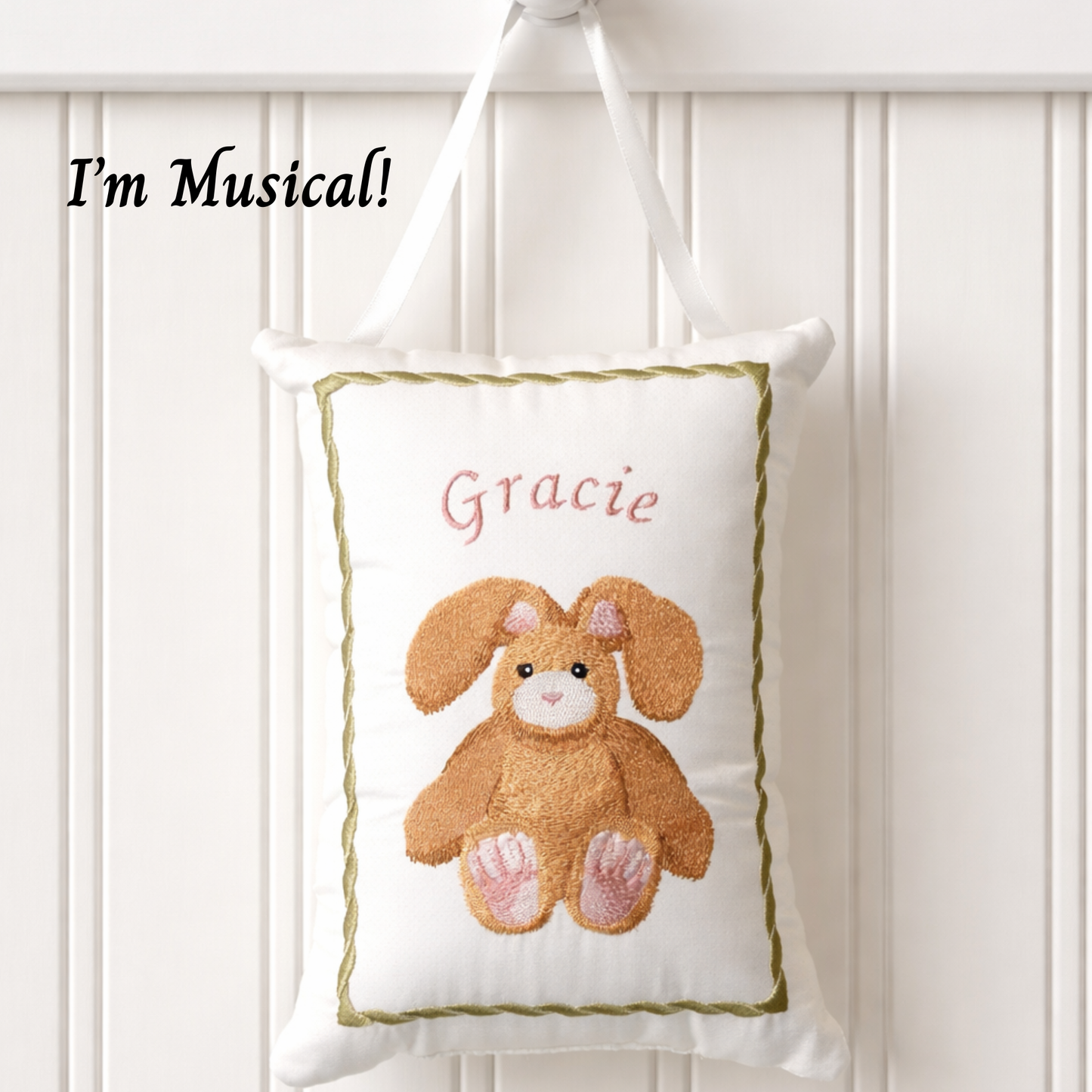 Decorative music box pillow with a bunny design and the name 'Gracie' on a white background.