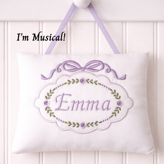 Embroidered music box pillow with 'Emma' and floral design on a white background