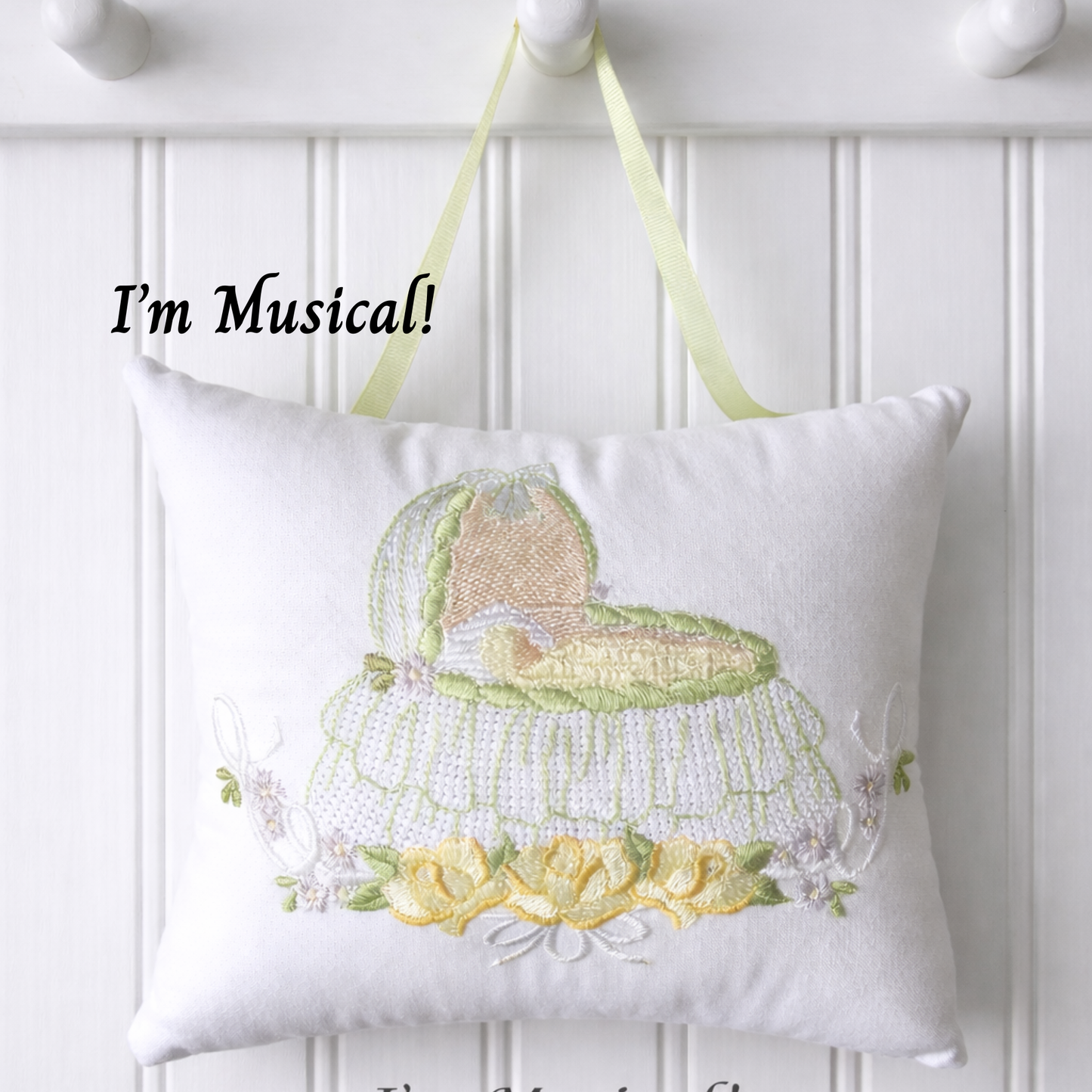 Decorative music box pillow with musical design on a white wall.