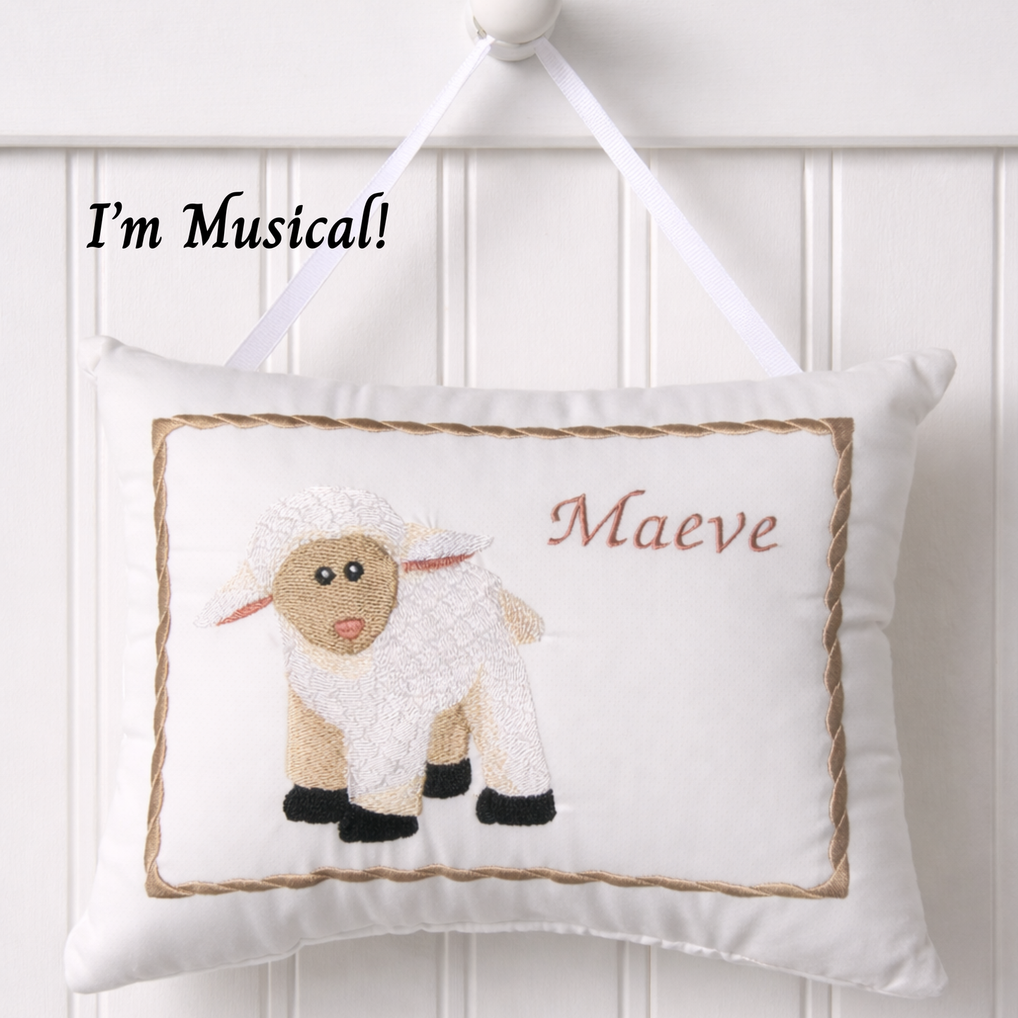 Decorative music box pillow with a sheep design and text 'I'm Musical! Maeve' on a white background