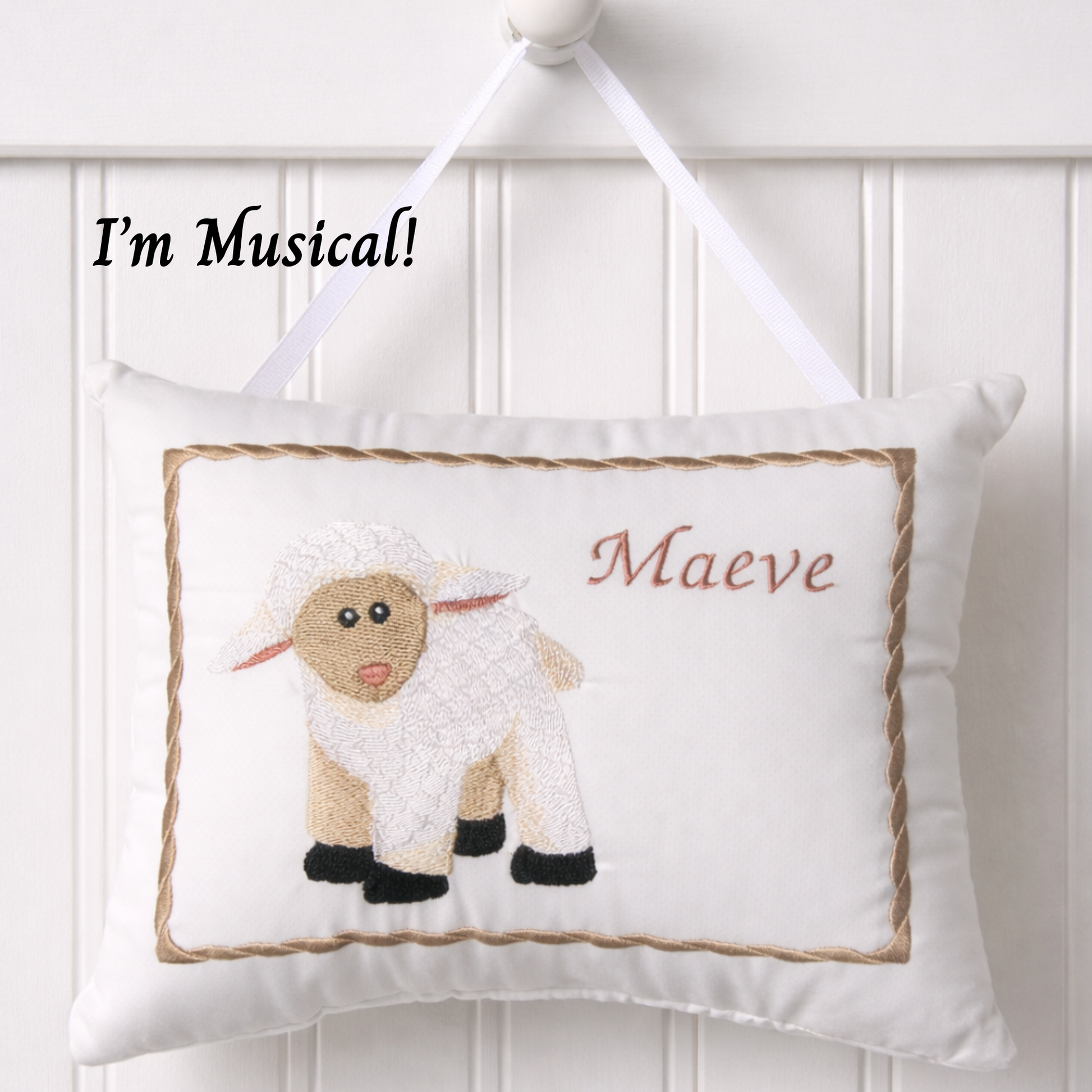 Decorative music box pillow with a sheep design and text 'I'm Musical! Maeve' on a white background
