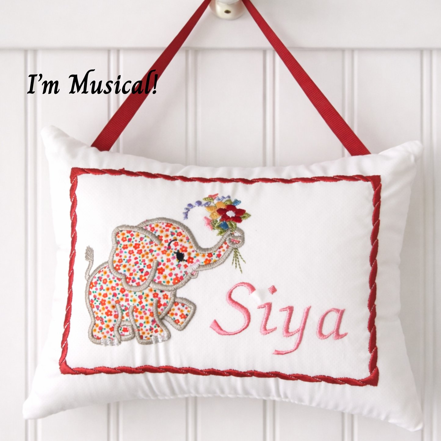 Decorative music box pillow with a floral elephant design and the name 'Siya' on a white background.