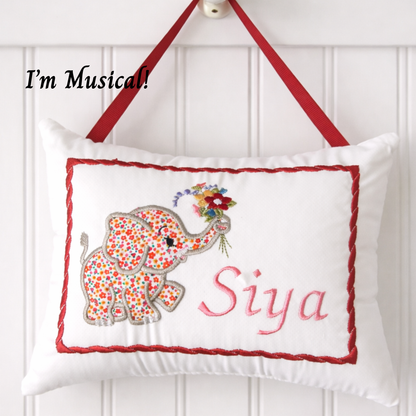 Decorative music box pillow with a floral elephant design and the name 'Siya' on a white background.