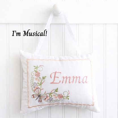 White music box pillow with butterfly floral design and 'Emma' embroidery on a white background