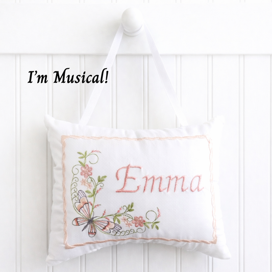 White music box pillow with butterfly floral design and 'Emma' embroidery on a white background