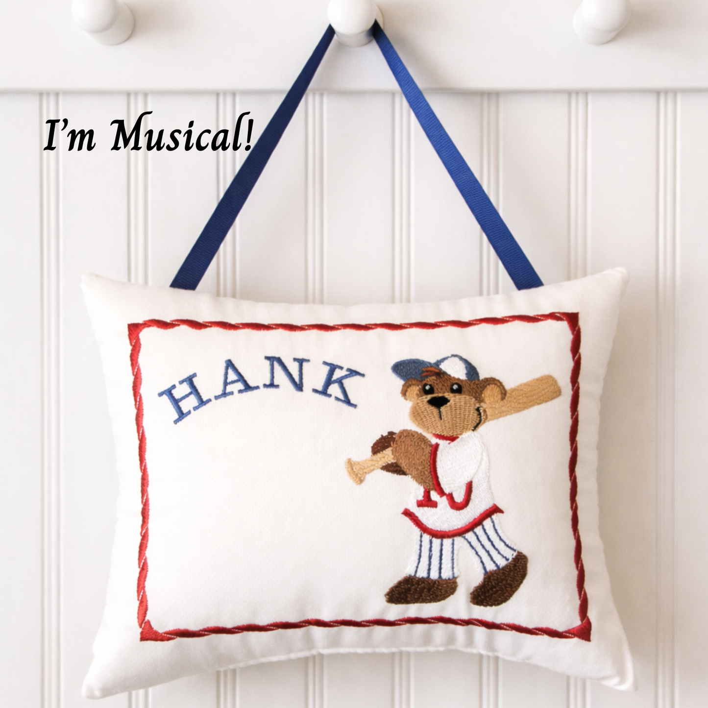 Decorative music box pillow with a baseball-themed bear design and the name 'Hank' on a white background.