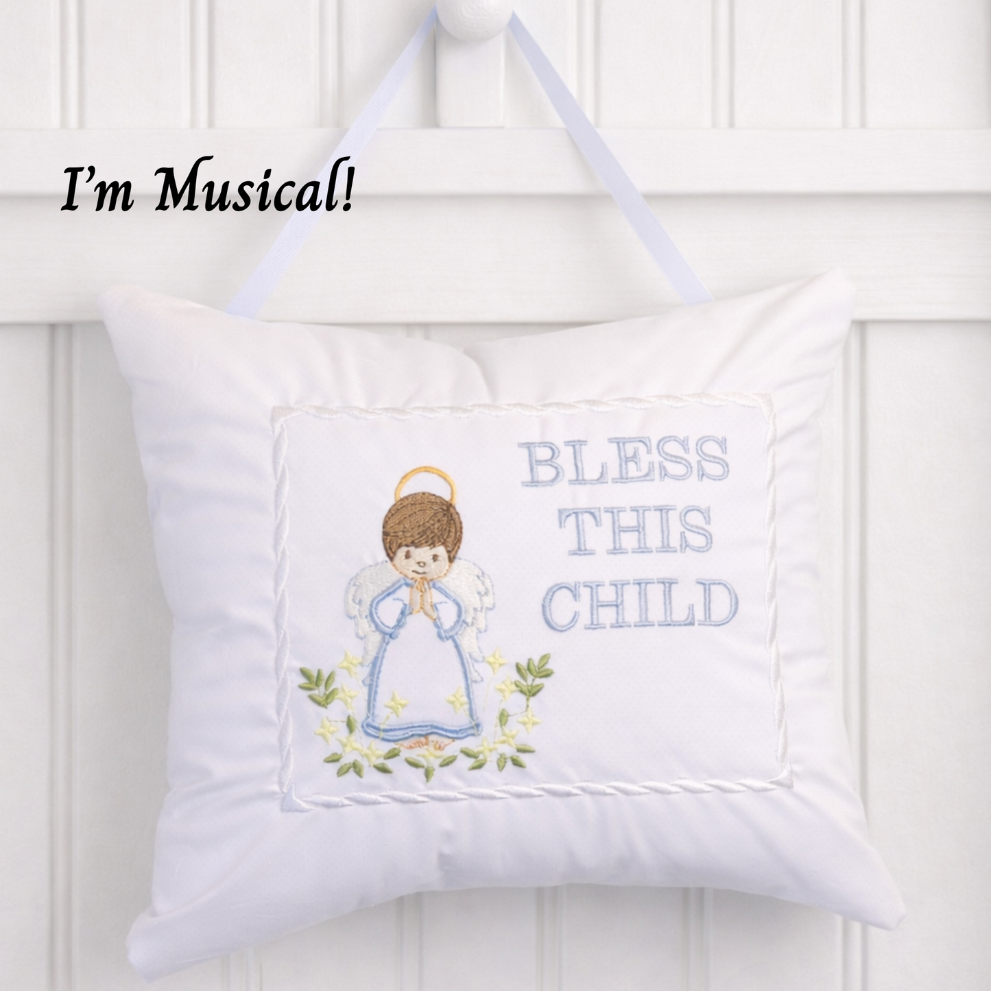 White music box pillow with angel design and 'Bless This Child' text on a white background