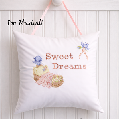 Decorative music box pillow with embroidered design and text 'Sweet Dreams' on a white background