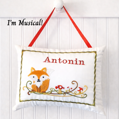 Decorative music box pillow with embroidered fox design and text 'I'm Musical! Antonin' on a white background.