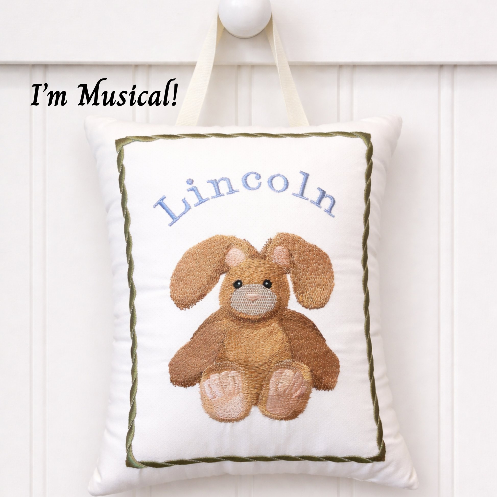 Decorative music box pillow with a bunny design and embroidered name 'Lincoln' on a white background.