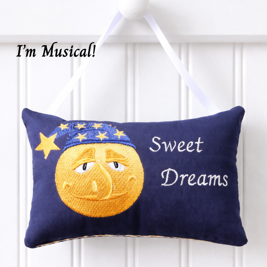 Decorative music box pillow with a moon face and 'Sweet Dreams' text on a white background