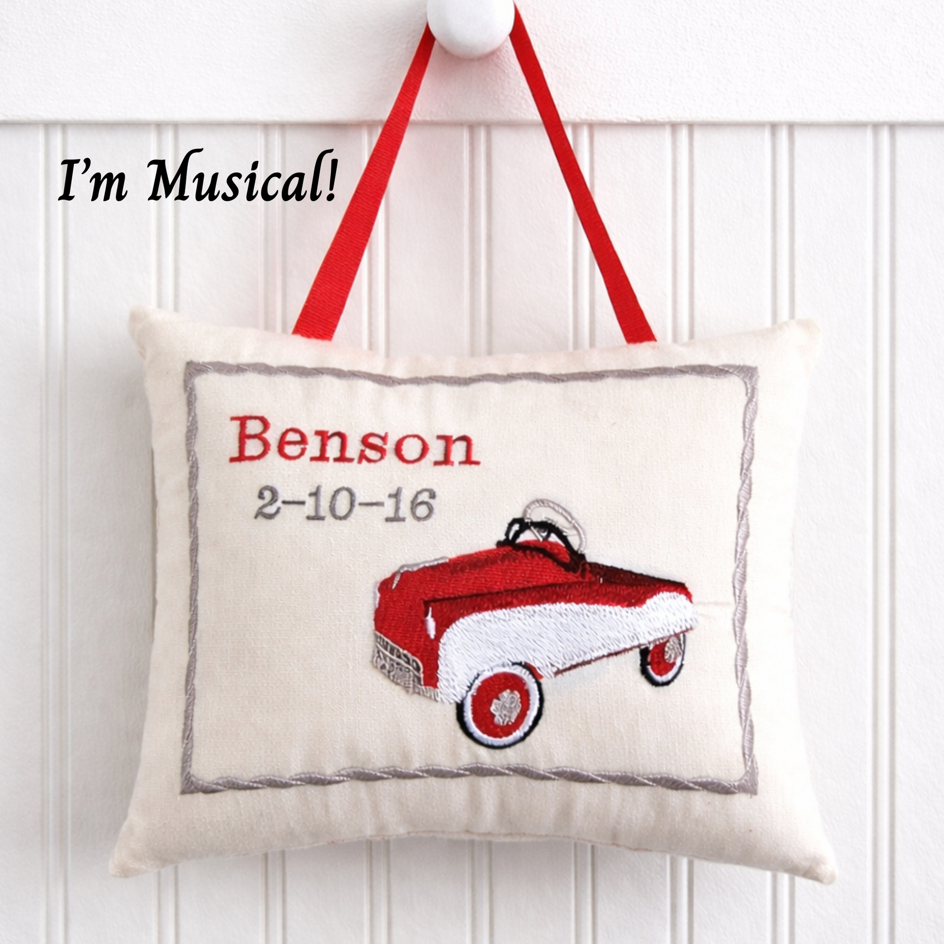 Decorative music box pillow with a red toy car design and text on a white background