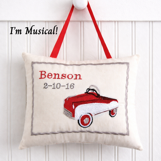 Decorative music box pillow with a red toy car design and text on a white background