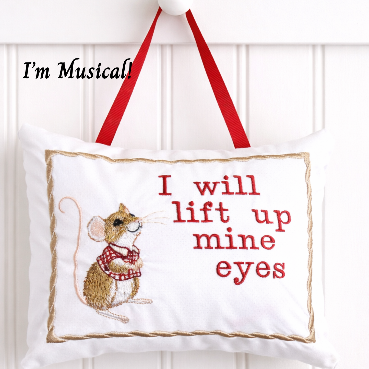 Decorative music box pillow with embroidered mouse and text on a white background