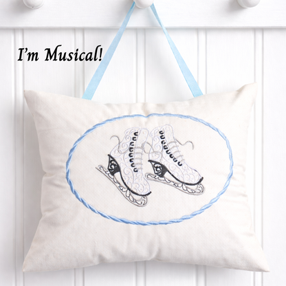 White music box pillow with ice skates design and text 'I'm Musical!' on a white background