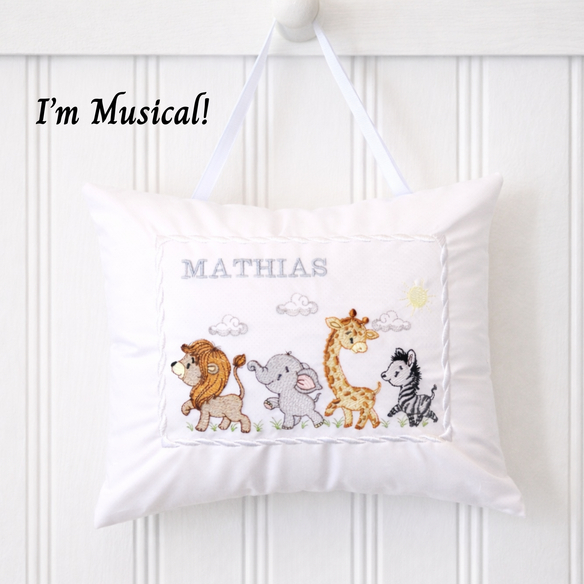 Children's musical pillow with embroidered jungle safari animals and name 'Mathias' on a white background