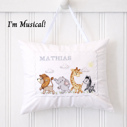 Children's music box pillow with embroidered jungle safari animals and name 'Mathias' on a white background
