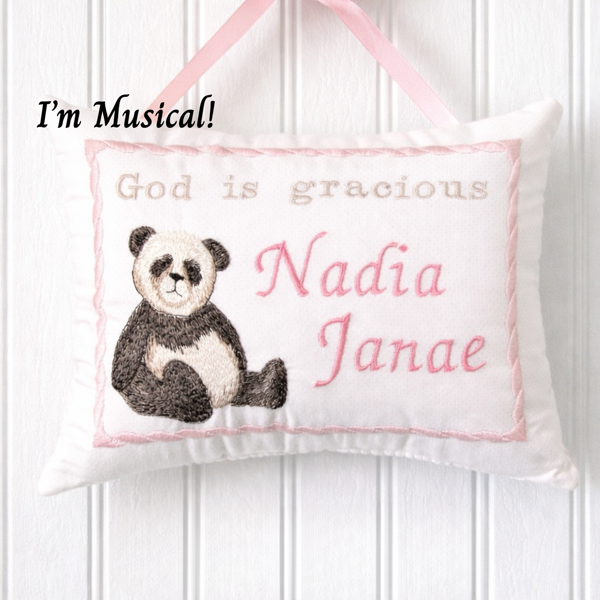 Decorative music box pillow with a panda illustration and embroidered text on a white background