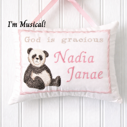 Decorative music box pillow with a panda illustration and embroidered text on a white background