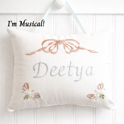 Decorative music box pillow with embroidered name 'Deetya' and decorative elements on a white background.